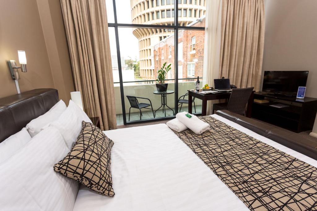 um quarto de hotel com uma cama e uma grande janela em Clarendon Hotel em Newcastle