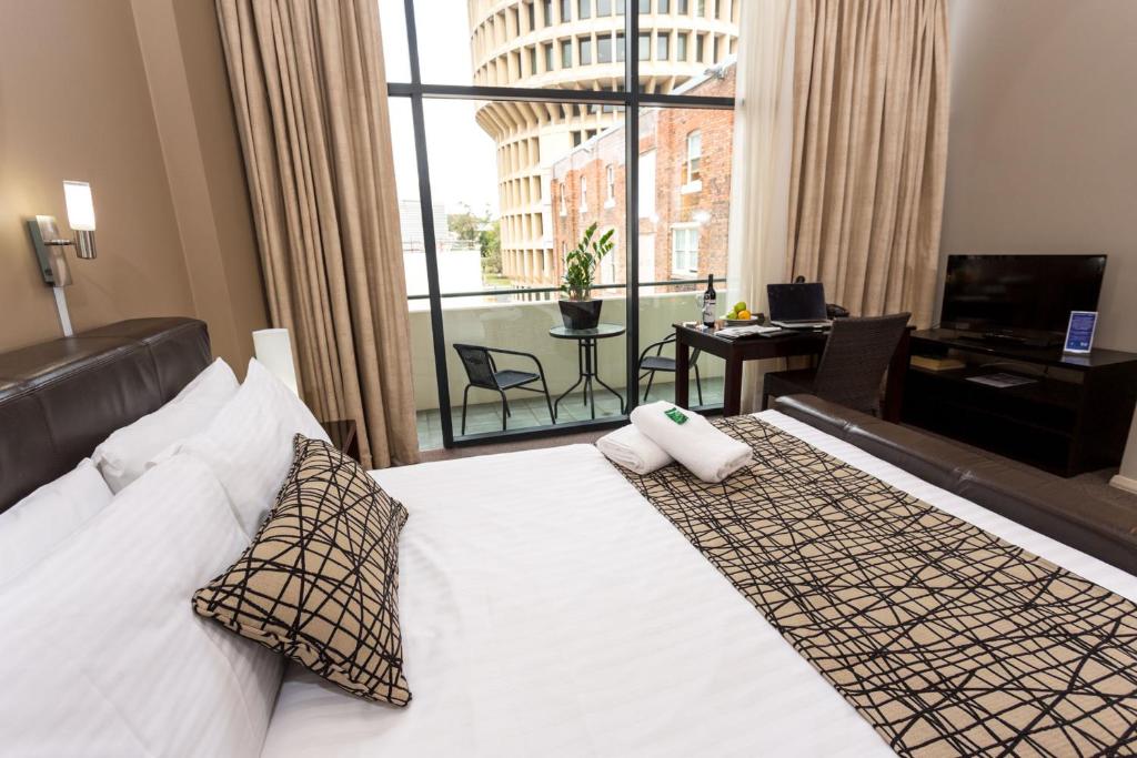 纽卡斯尔Clarendon Hotel的一间带床和大窗户的酒店房间