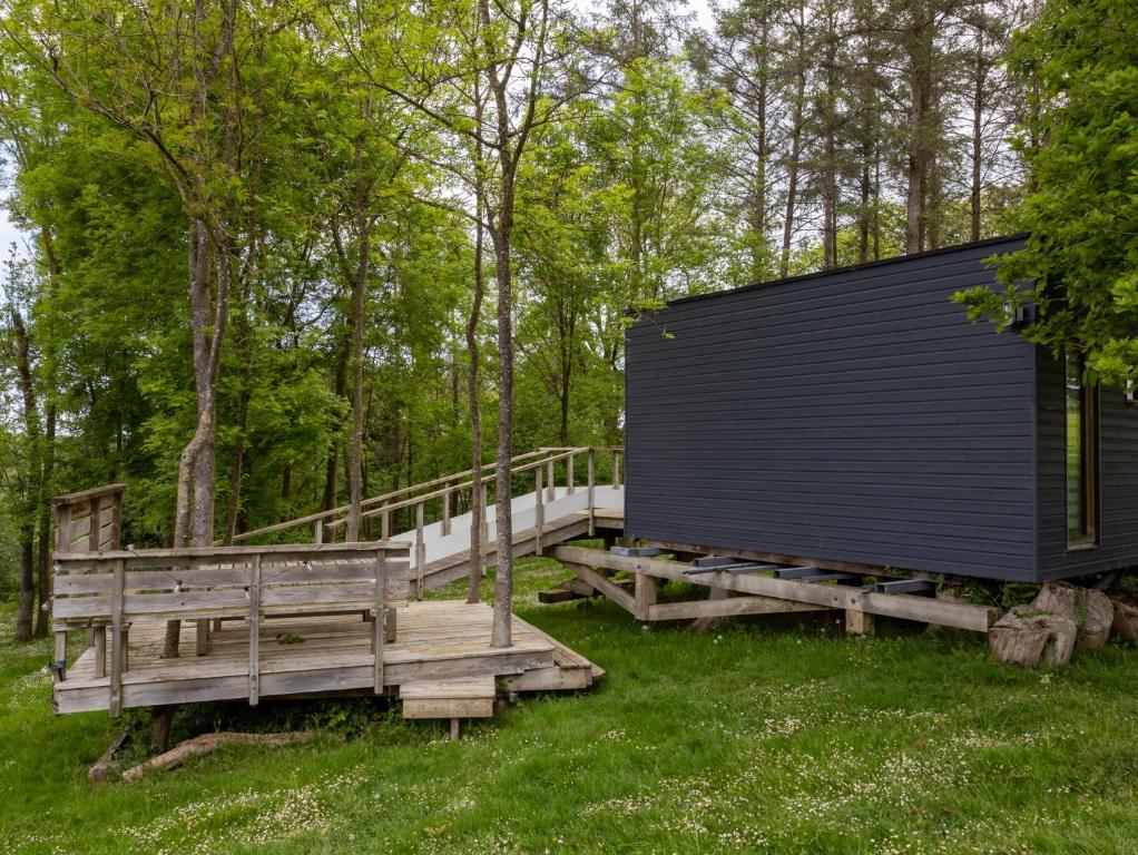 a building with two benches and a wooden deck at La Cafoutche de Minus rénovée 2pers in Gommenecʼh
