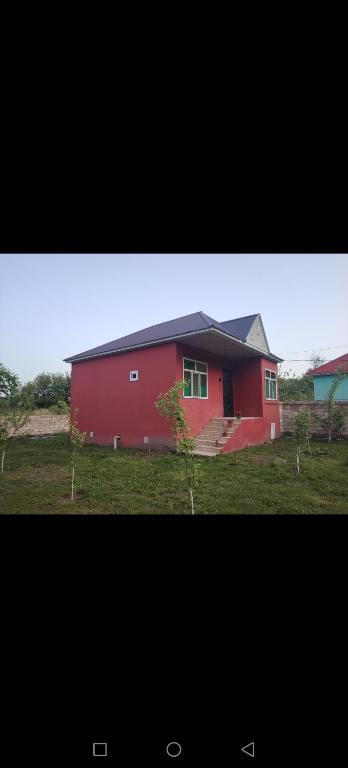 ガバラにあるGabala Cheap houseの畑の隣の畑にある赤い納屋