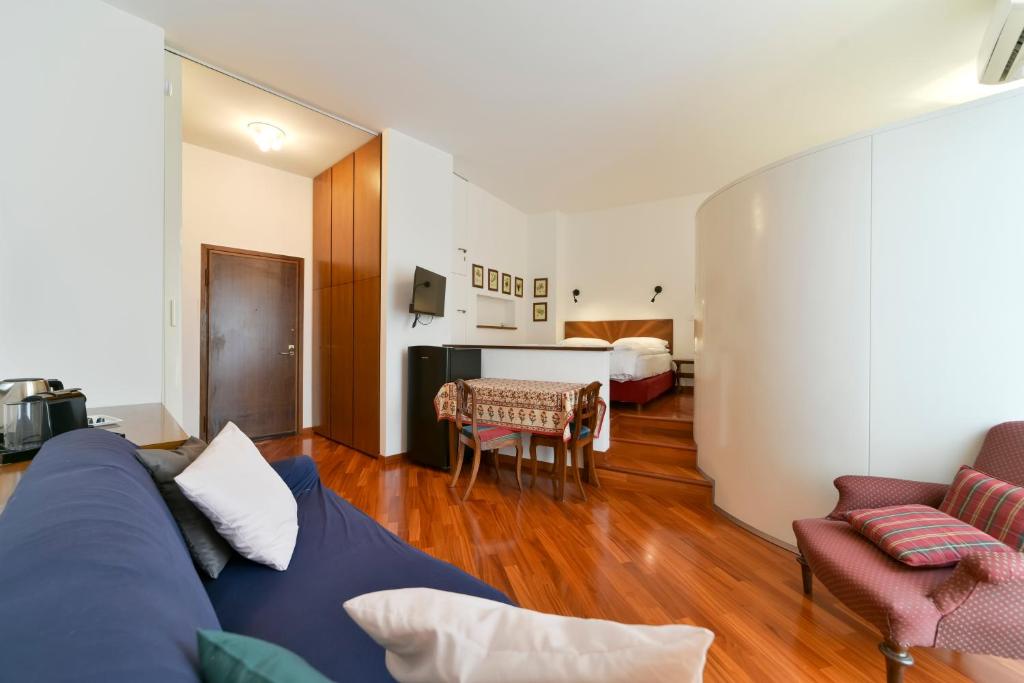 ein Wohnzimmer mit einem blauen Sofa und ein Schlafzimmer in der Unterkunft Monforte 19 - Milano in Mailand
