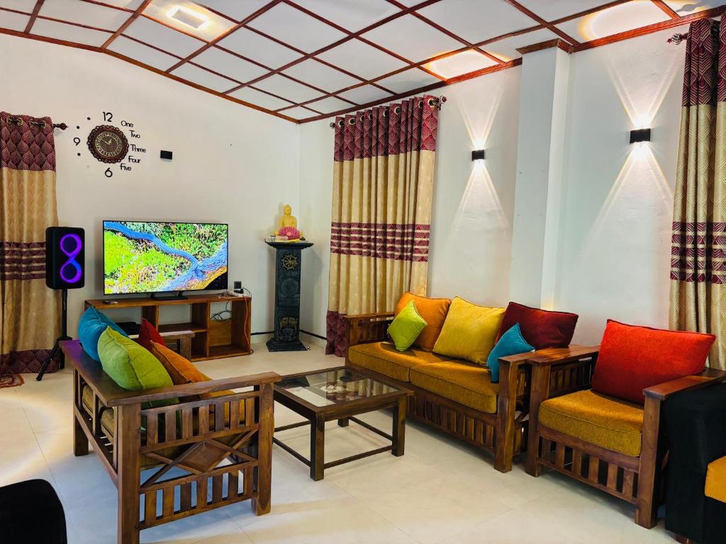 Una sala de estar con dos sofás y un televisor. en Madiriya Forest Lodge, en Badulla