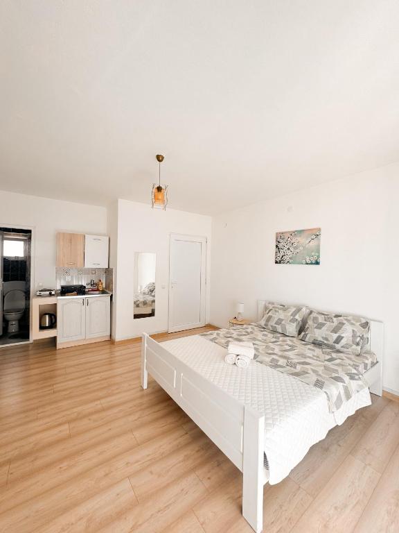a white bedroom with a bed and a kitchen at Lemon&Olives in Budva