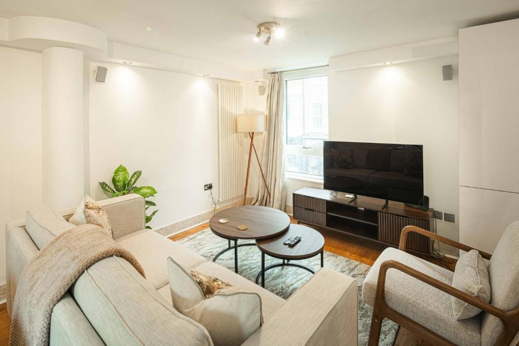 ein Wohnzimmer mit Couch und Fernseher in der Unterkunft Stylish 3BD Flat in Prime Covent Garden Location in London
