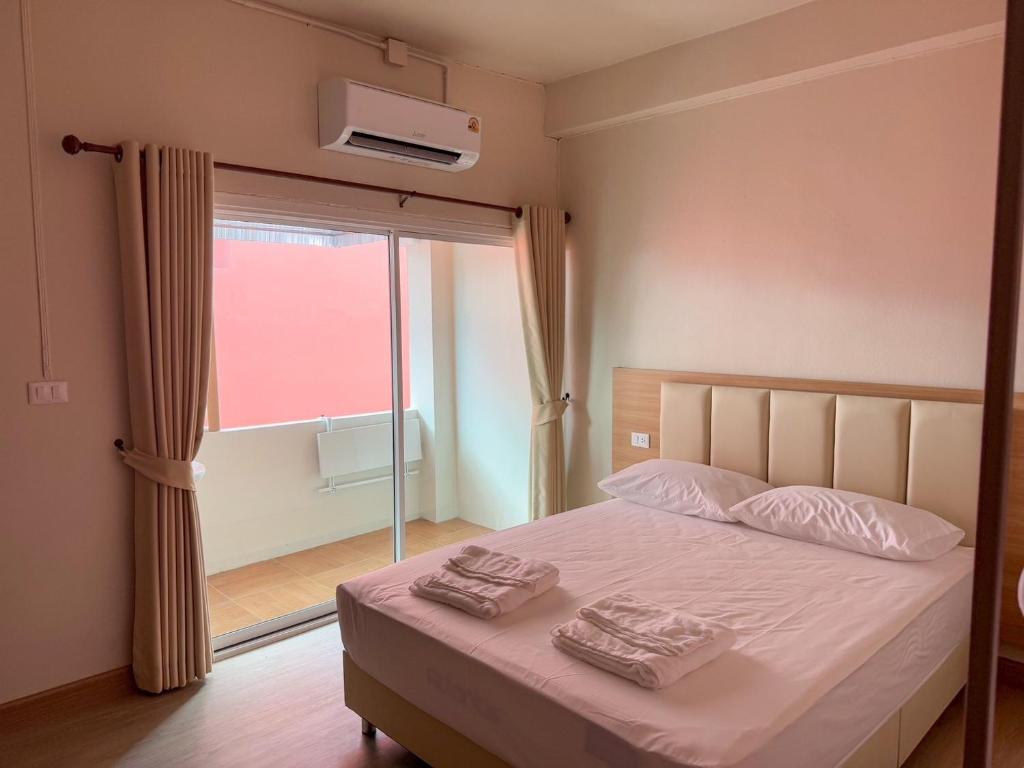 ein Schlafzimmer mit einem Bett, auf dem zwei Handtücher liegen in der Unterkunft Apartment Near Big Buddha in Bangkok Yai