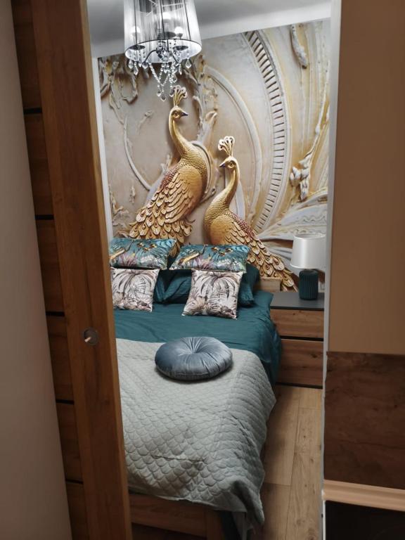 a bedroom with a bed with two gold peacocks on it at Apartament Królewskie Pawie in Sandomierz