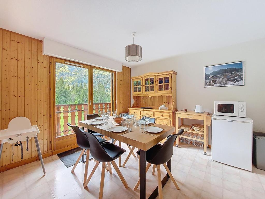 une cuisine avec une table et des chaises dans une pièce dans l'établissement Grand Cerf 62, à Saint-Jean-dʼAulps