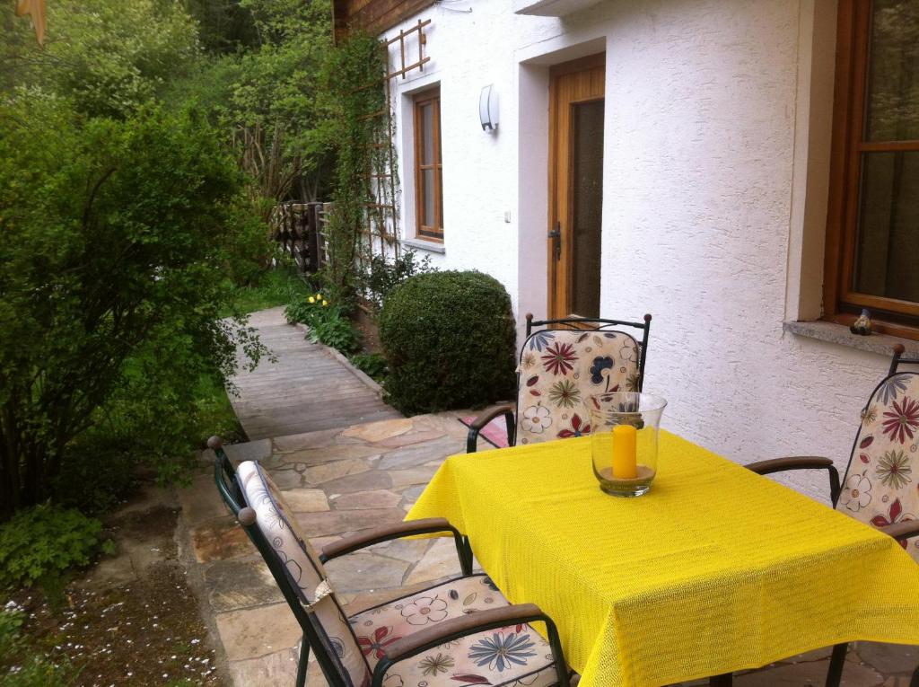 ein gelber Tisch und Stühle mit einem gelben Tischtuch in der Unterkunft Ferienwohnung Grössenberg in Weißkirchen in Steiermark