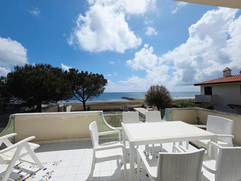a patio with a table and chairs and the ocean at VILLA I DELFINI - Terracina Fronte Mare in Lido Di Fondi