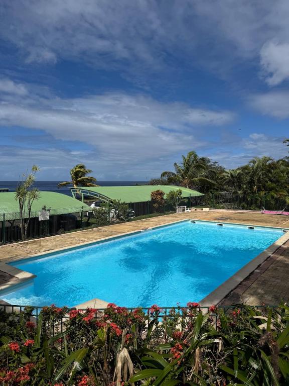 a blue swimming pool with a view of the ocean at AZURÉA Marina ! in Gourbeyre