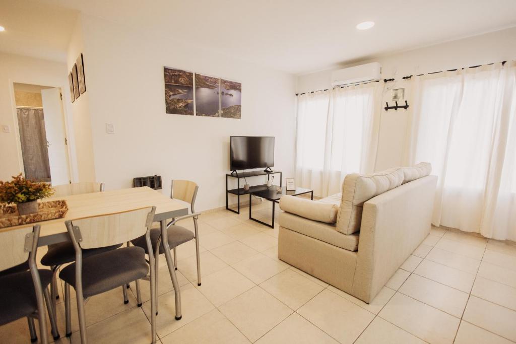 a living room with a table and chairs and a television at Complejo Coirón in San Rafael