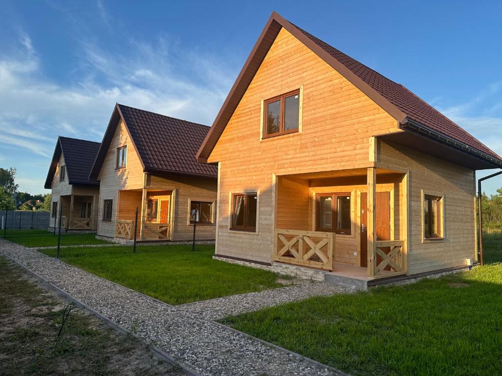 a wooden house with a gambrel roof at Uroki Roztocza w Krasnobrodzie in Krasnobród
