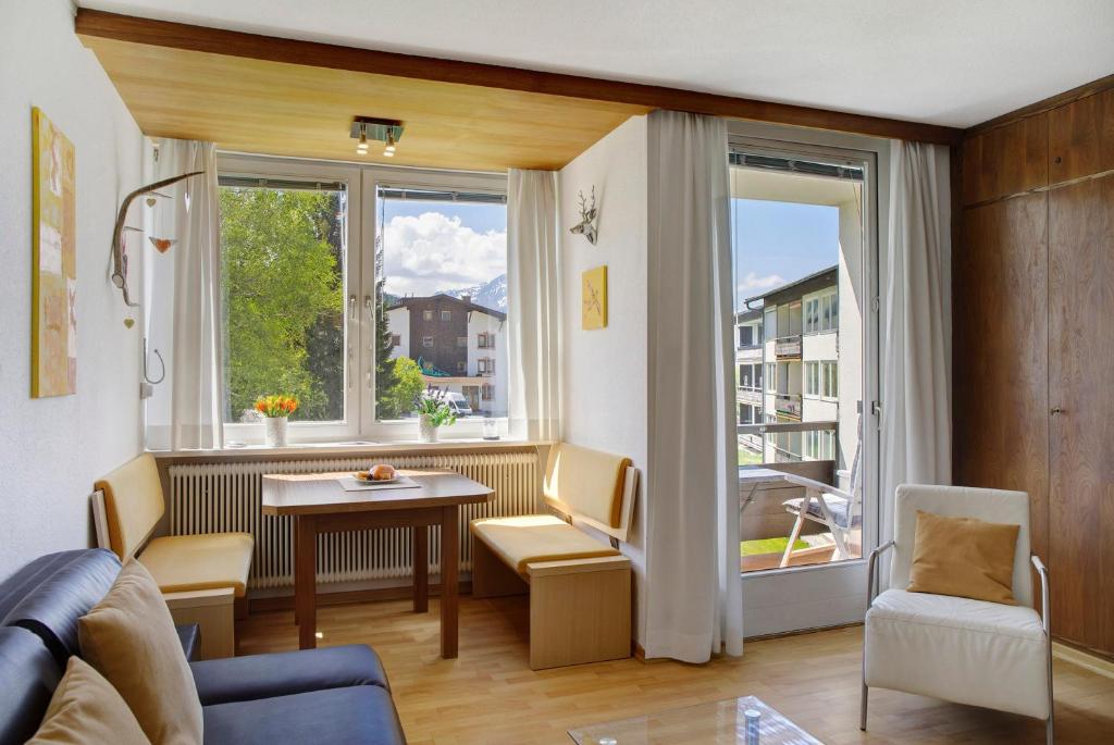 sala de estar con sofá, mesa y ventanas en Suite Harmony, en Seefeld in Tirol