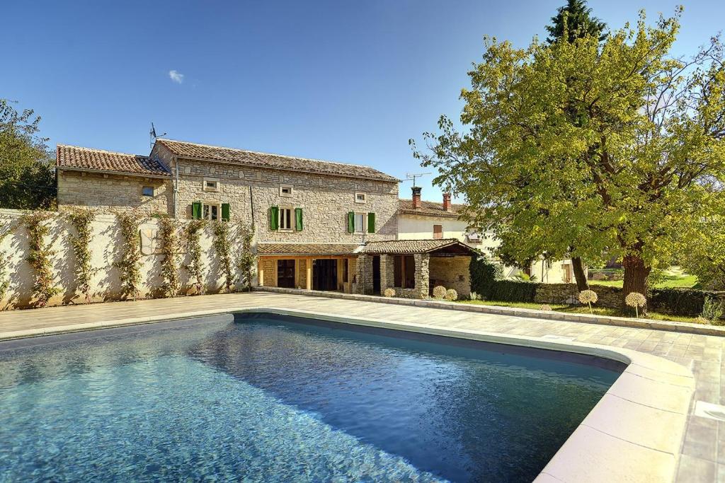 a swimming pool in front of a house at Villa Krase in Svetvinčenat