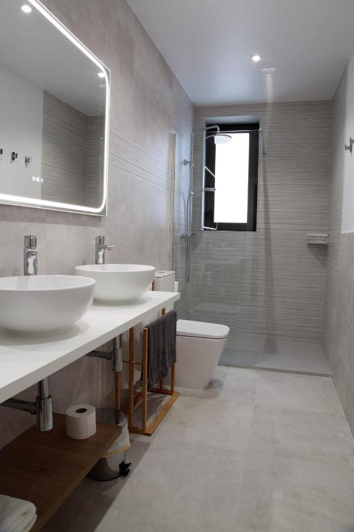 a bathroom with two sinks and a toilet at La Estrella de Tarsis in Santillana del Mar