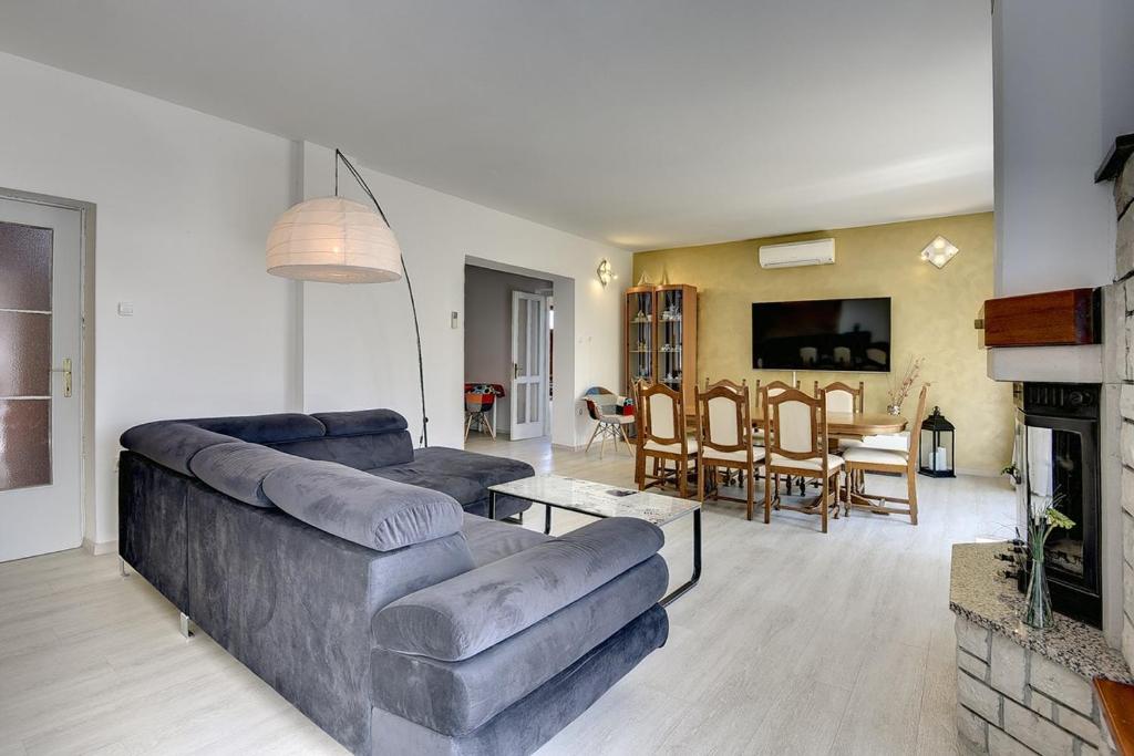 salon z kanapą i jadalnią w obiekcie Villa Golf w mieście Ližnjan