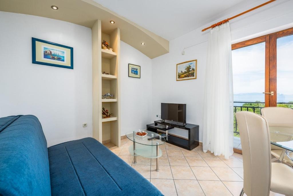 a living room with a blue couch and a table at Ferienwohnung 5235-5 in Drenje in Drenje