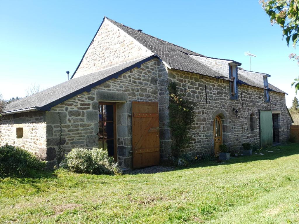 une vieille maison en pierre avec une grande cour dans l'établissement Longère Coeur Bretagne, à Le Croisty