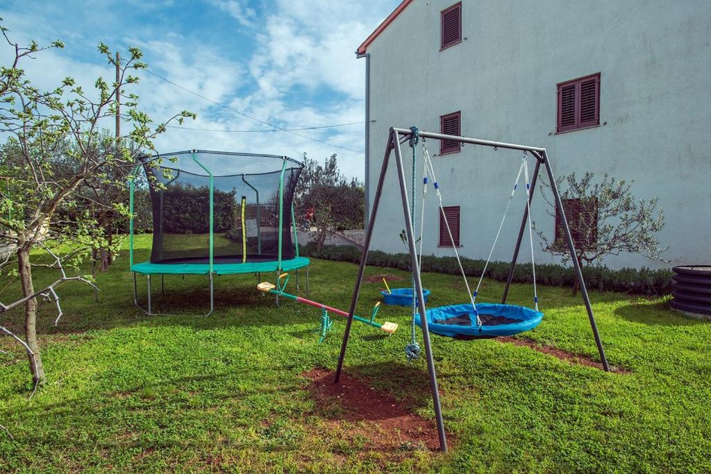 two swings in a yard next to a house at Apartment Falu in Štinjan