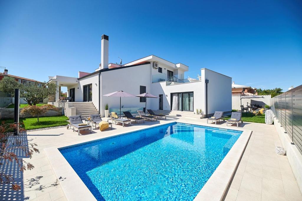 a villa with a swimming pool in front of a house at Villa Dolcea in Umag