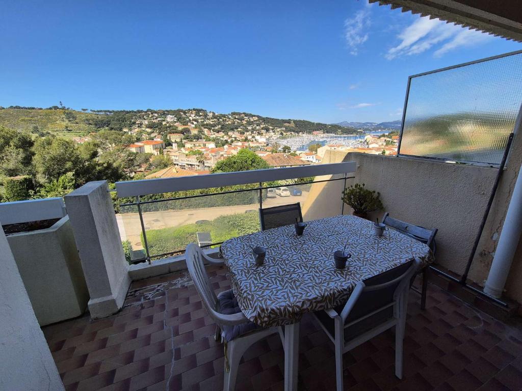 une table et des chaises sur un balcon avec vue dans l'établissement Vue mer, plage à pied – Résidence avec piscine tennis, à Saint-Mandrier-sur-Mer