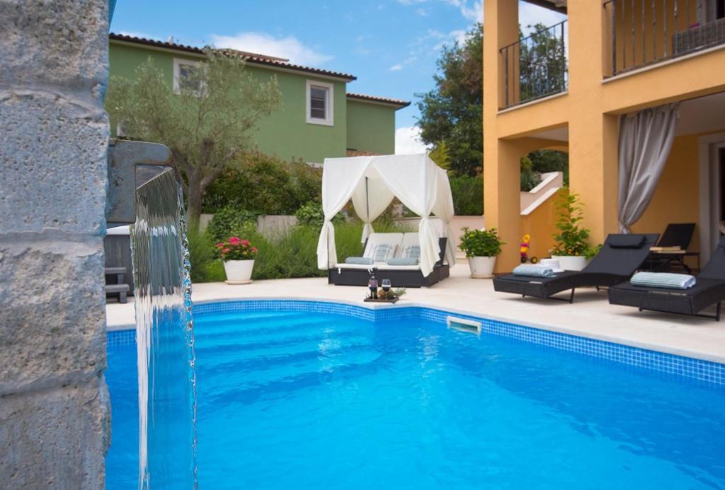 a swimming pool in front of a house at Villa Ari in Krnica
