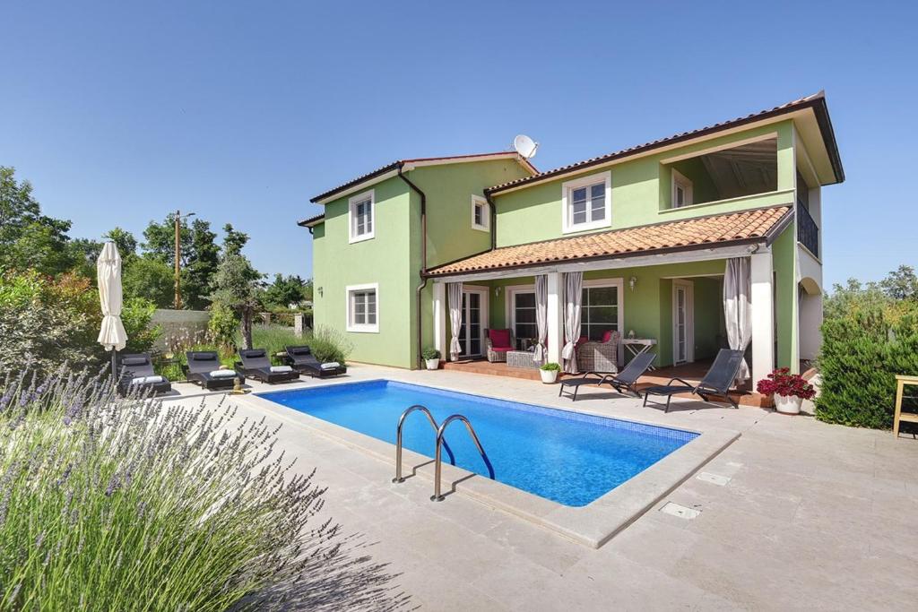 a house with a swimming pool in front of it at Villa Oliva in Krnica