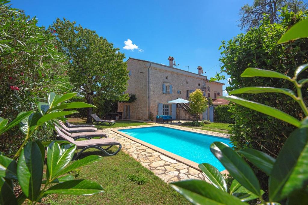 a swimming pool in front of a house at Villa Sherpa in Poreč