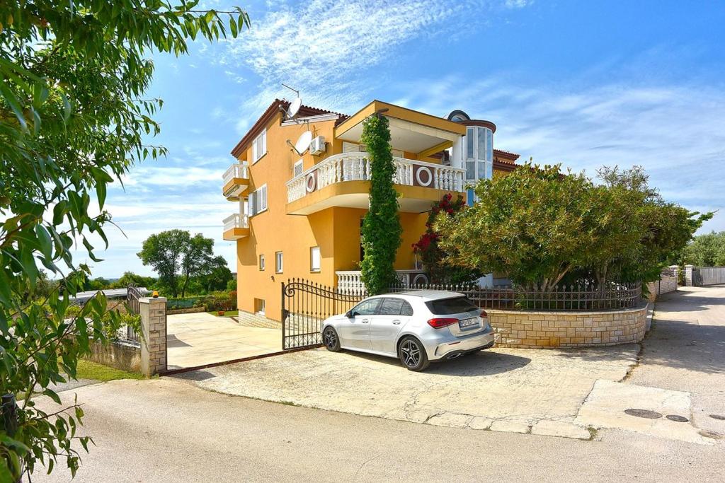 a car parked in front of a house at Apartments Sunset in Vodnjan
