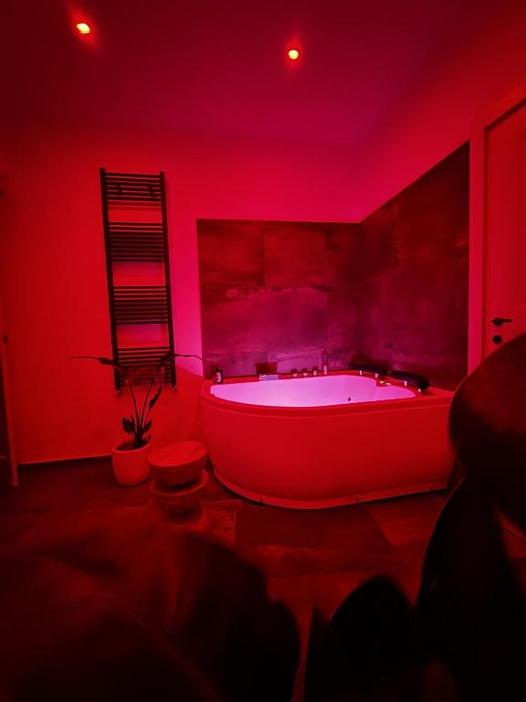 a red bathroom with a large tub in a room at Zephir Green in Brindisi