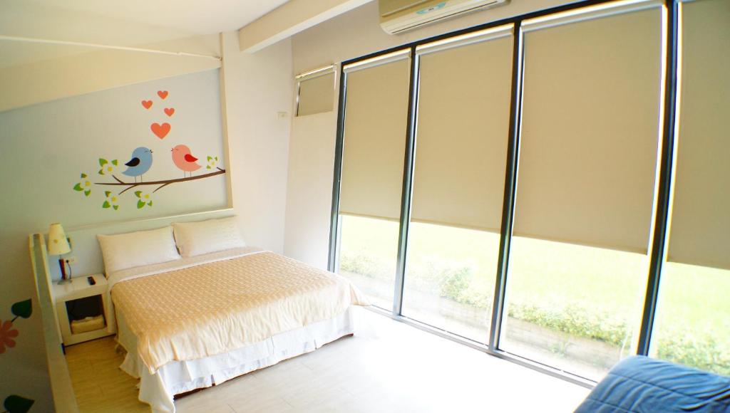 a bedroom with a bed and a large window at Lan Yang Resort Four Seasons in Dongshan