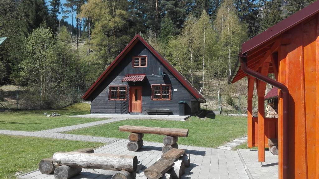 uma pequena cabana com um banco à frente em Chata Bielo em Liptovský Ján