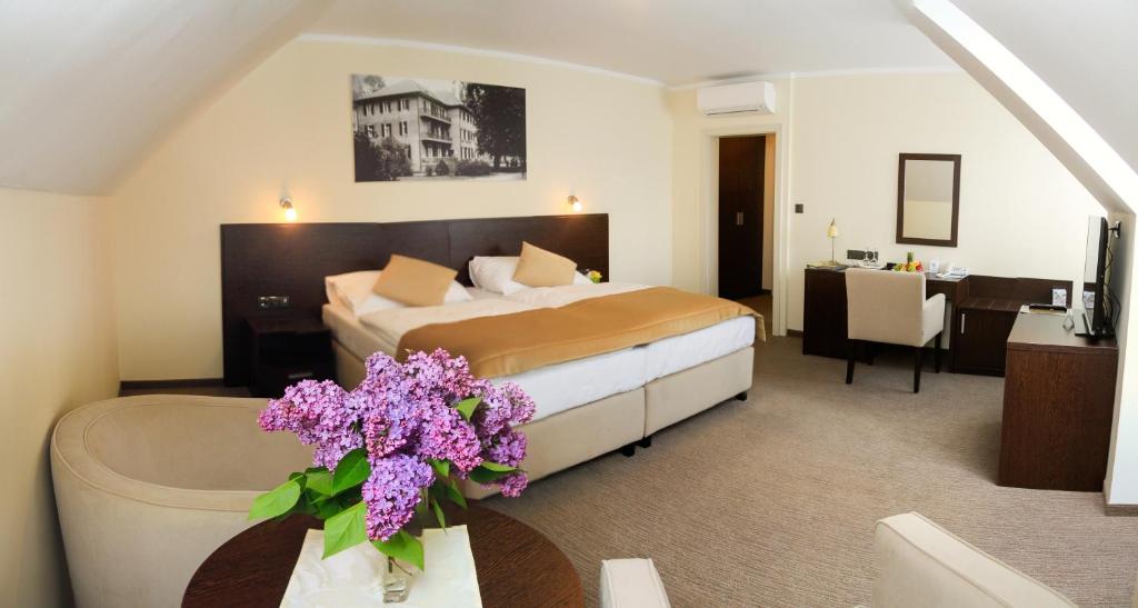a hotel room with a bed and a table with flowers at Ensana Pro Patria in Piešťany