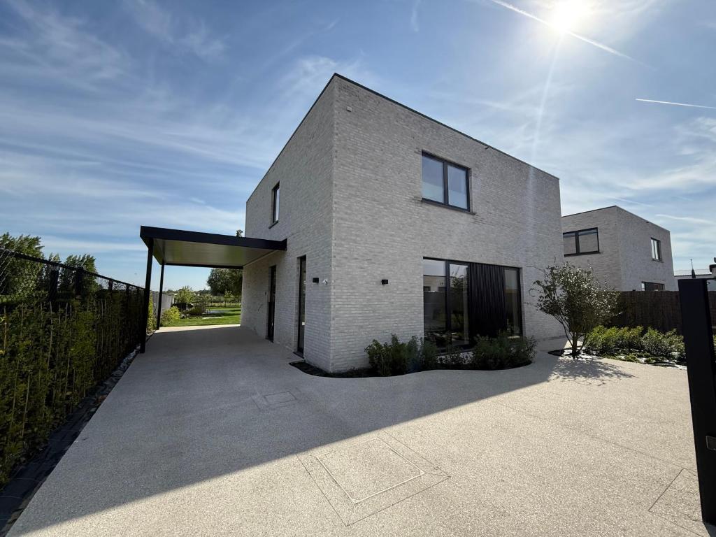a white brick house with a garage at Maison Impression vakantiehuis in Middelkerke