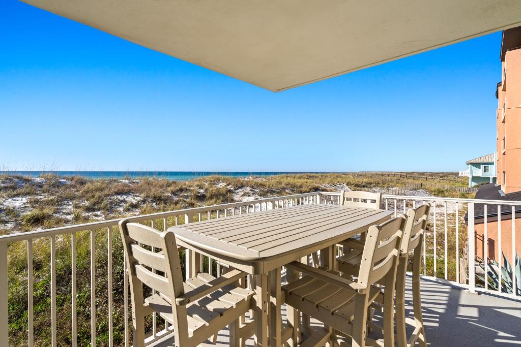 a table and chairs on a balcony with the beach at Starboard Village Unit 612 in Pensacola Beach
