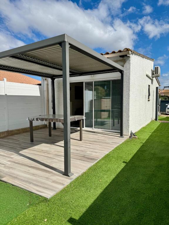 - un pavillon avec une table de pique-nique sur une terrasse en bois dans l'établissement Studio Plein sud -Histoire de clés, à Agde