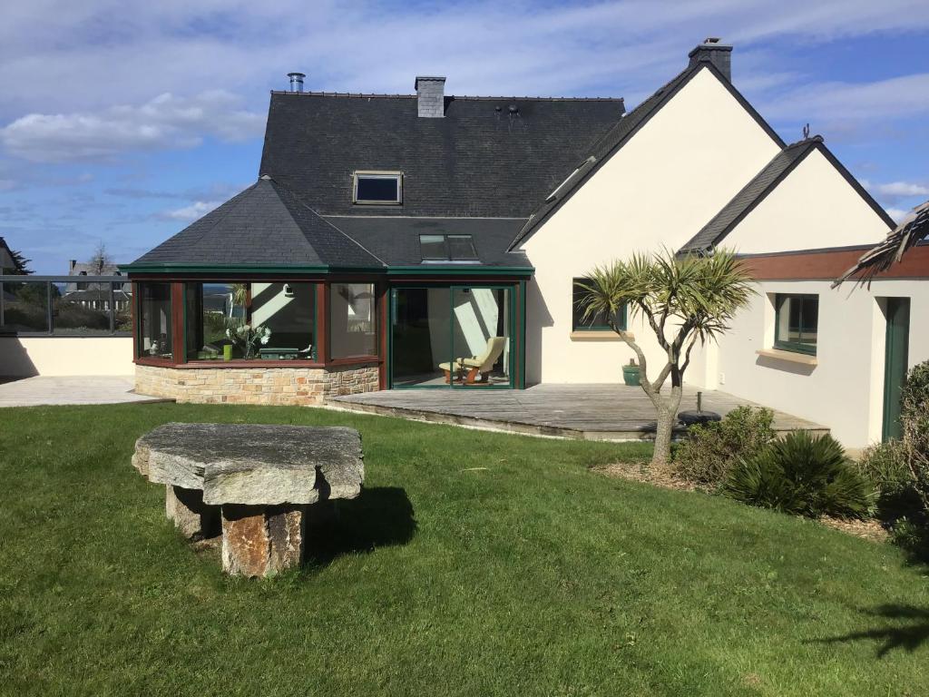 une maison avec un banc en pierre dans la cour dans l'établissement Maison calme, vue sur mer, à Saint-Pabu