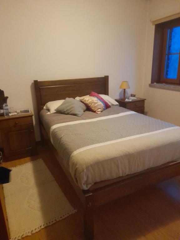 a bed with two pillows on it in a bedroom at Latada Suit's Serra da Estrela in Sameiro