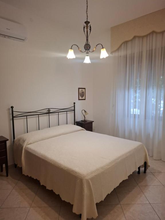 a bedroom with a bed and a chandelier at Casa Anna in Padru