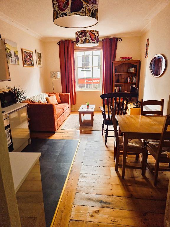 a living room with a couch and a table at Historic Gloucester Stay - A Hidden Gem in Gloucester