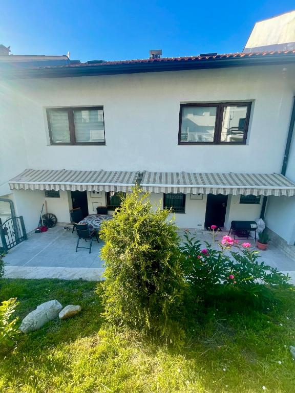a white house with a patio and a porch at Golden Valley in Sarajevo