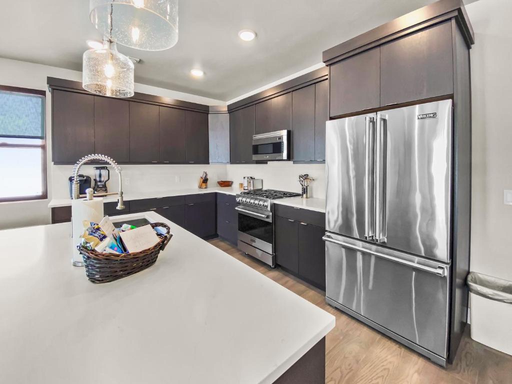a kitchen with a stainless steel refrigerator and a counter at 204 Jordanelle Mountain Paradise by SkyRun Park City in Heber City