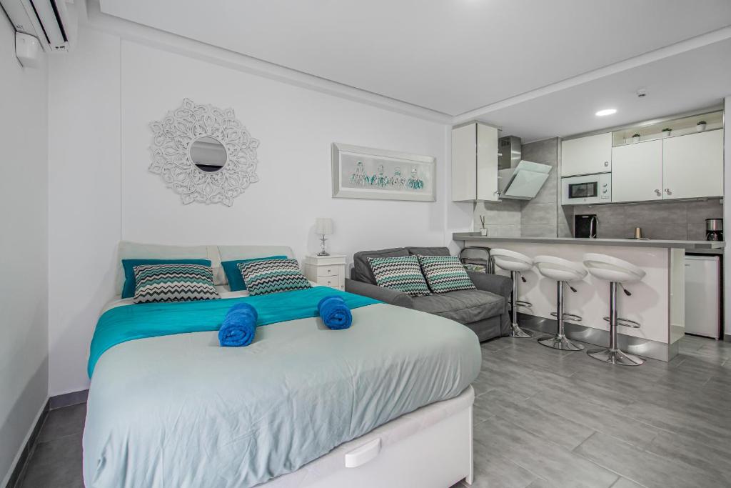 a bedroom with a large bed and a kitchen at Puerto Cruz Relaxing Shared Pool in Puerto de la Cruz
