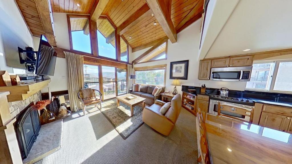 een keuken met een woonkamer met een bank en een televisie bij Crestwood 1313 Deluxe 1 Bedroom plus Loft in Snowmass Village