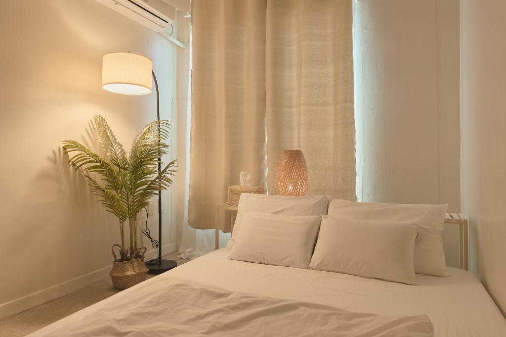 ソウルにあるSeoul Sensibility B&B Houseのベッドルーム1室(白いシーツと植物付)