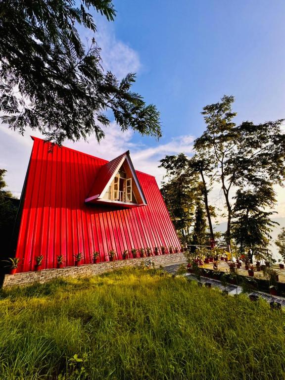 a red roofed house with a red roof at The Tea Tribe Stay in Sonāda