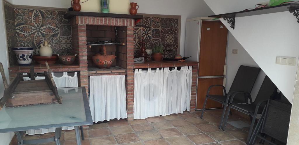 a living room with white curtains and a fireplace at Casa Campanilla Valle De Abdalajis in Valle de Abdalagís