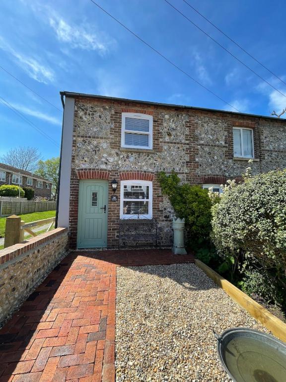 a brick house with a green door at Evergreen Cottage in East Preston