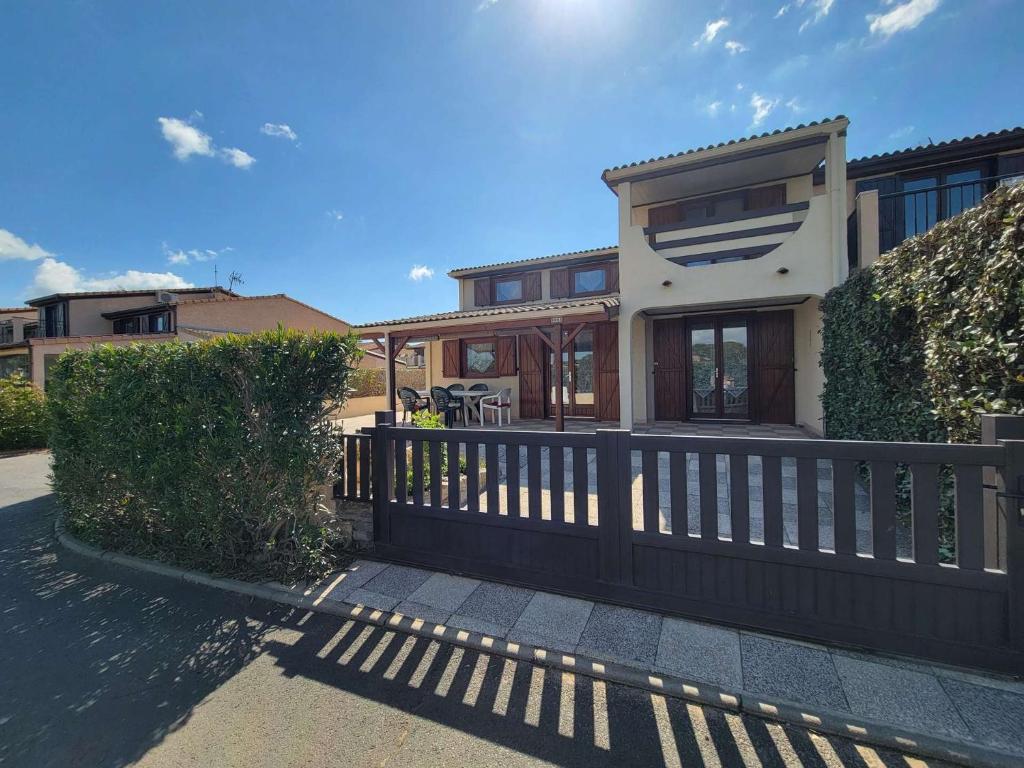 une maison avec une clôture devant dans l'établissement Belle villa d'angle climatisée dans domaine de vacances PORTES DU SOLEIL, 3 chambres, 6 couchages, fibre Wifi, à PORTIRAGNES PLAGE LRPDSH5, à Portiragnes