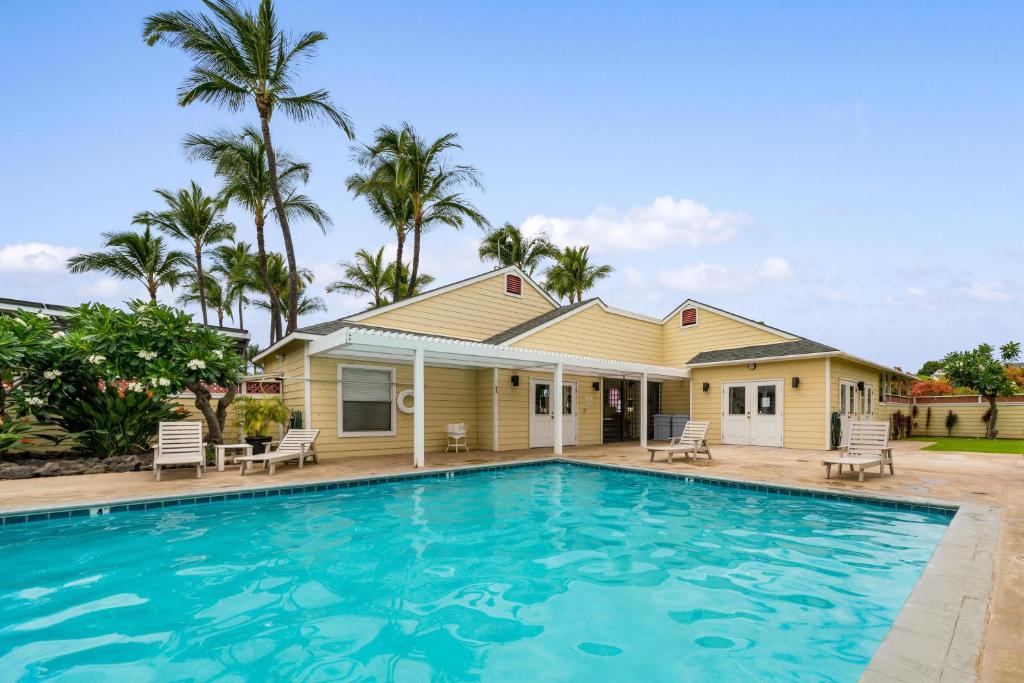a house with a swimming pool in front of a house at Big Island Fairway Terrace J-107 by Coldwell Banker Island Vacations in Waikoloa Village